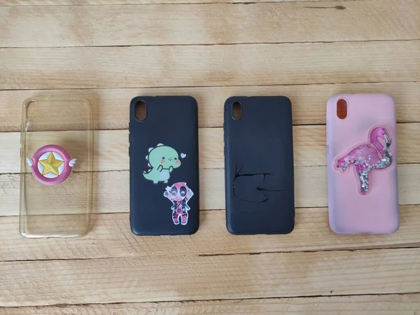 Ahşap bir arka planda çok renkli telefon kılıfları.