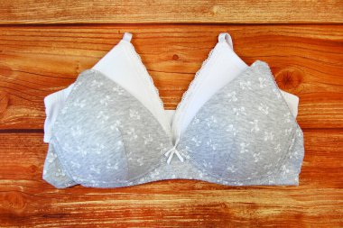 Ahşap arka planda beyaz ve gri sutyenler