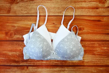 Ahşap arka planda beyaz ve gri sutyenler