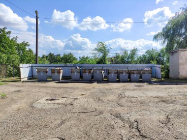 Çöp kutusu ve bir sıra çöp tenekesi.