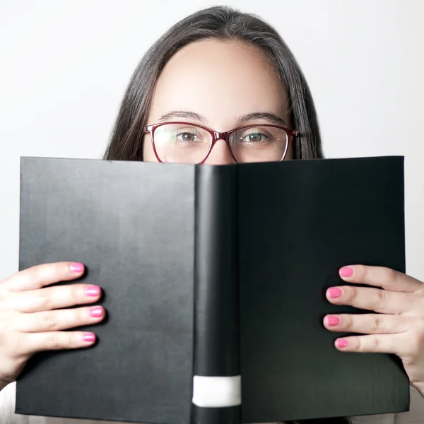 Closeup büyük siyah kitap - kavram öğrenme okuma gözlük gülümseyen genç kadın portresi