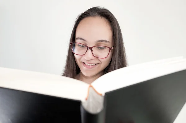 Closeup büyük siyah kitap - kavram öğrenme okuma gözlük gülümseyen genç kadın portresi