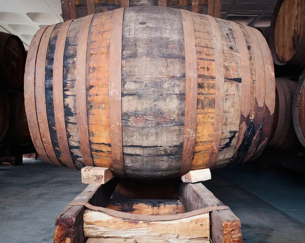 Close up of old oak wine barrel with wine drips, leak traces. Contents are leaking down the side of barrel.