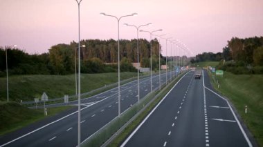 Günbatımında arabalarla dört şeritli yeni bir yolun hızlandırılmış çekimi