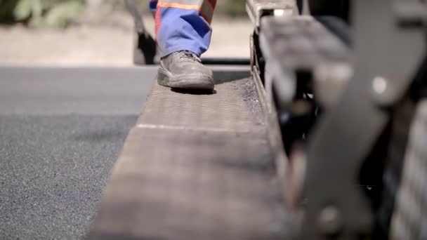 Costruttore di strada uomo a piedi su una scala macchine all'aperto in salopette — Video Stock