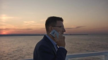 Gün batımında Tahta İskeleye Çağrı Yapan Yakışıklı İş Adamı