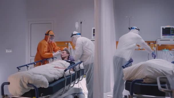 코로나 바이러스로 인 해 고통을 겪고 있는 환자에게 산소 마스크를 쓰는 의사 — 비디오