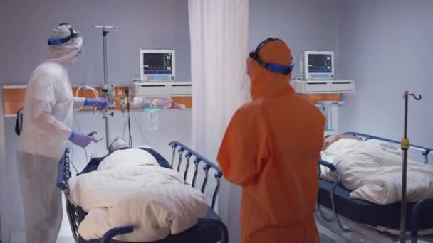 Toonaangevende arts controleert Coronavirus patiënten in quarantaine kamer — Stockvideo