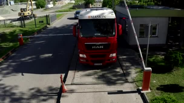 Camión rojo esperando que la barrera abra y salga del área de la fábrica — Vídeo de stock