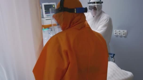 Slowmo - Le médecin en costume de protection orange vérifie le statut des patients atteints de coronavirus — Video