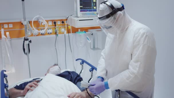 Médico en Traje Protector Medición de Pacientes con Coronavirus Presión arterial — Vídeo de stock