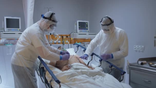 Slowmo - Dokter dengan baju pelindung Menempel ECG Memimpin pasien Coronavirus — Stok Video