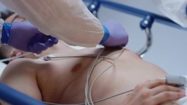 Slowmo - Koruyucu Takım Elbiseli Doktorlar ECG 'yi Coronavirus Hastasına Bağlıyor