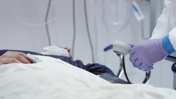 Доктор у захисному костюмі Вимірювання коронавірусу Пацієнти Кров'яний тиск — стокове відео