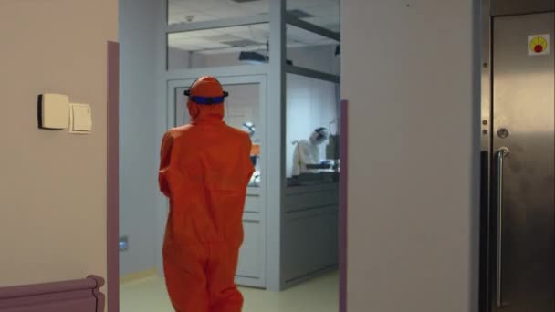 Doctor in an Orange Suit Enters Isolation Room with Coronavirus Patients — Stock Video
