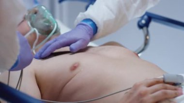 Koruyucu Takım Elbiseli Doktorlar EKG 'yi Coronavirus Hastasına Bağlıyor
