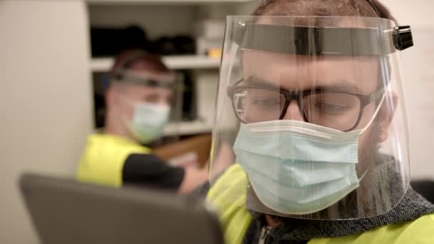 Slowmo: Arbeiders in beschermende gezichtsmaskers controleren inventaris in Fulfilment Center — Stockvideo