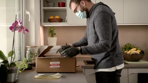 Slowmo: Ein Pandemie-COVID-19-Paket entpacken und dabei Schutzhandschuhe tragen — Stockvideo