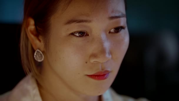 युवा एशियाई महिला गहराई से सोचा में अवशोषित जबकि कार्यालय में देर से काम — स्टॉक वीडियो