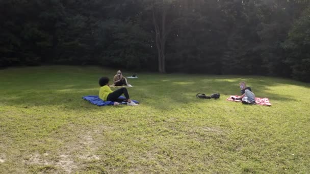 Jonge volwassenen sociale afstand in het groene park tijdens de pandemie — Stockvideo