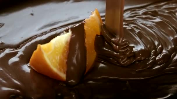 Slowmo naranja rebanada cayendo en el chocolate derretido y conseguir cubierto por el chocolate — Vídeos de Stock