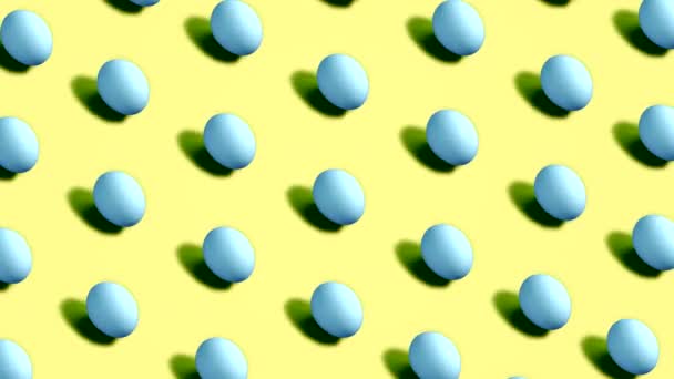 Huevos de Pascua coloridos girando en filas en bucle sin costuras sobre fondo amarillo — Vídeos de Stock