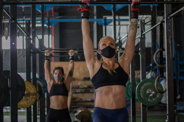 girls with mask in a gym doing cross training