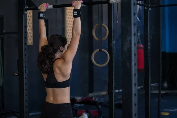 girl with mask in a gym doing cross training