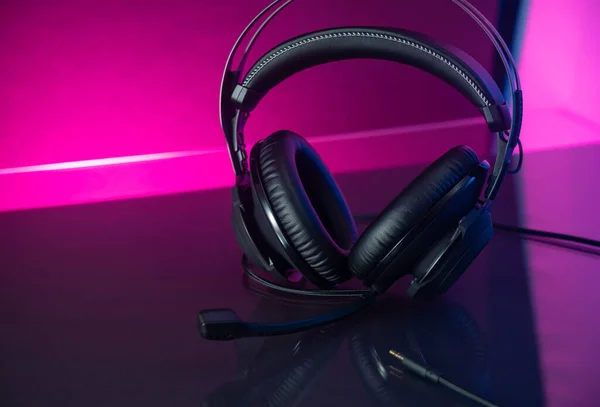 ゲーマーのヘッドフォン暗い背景とカラフルなピンクの光 — ストック写真