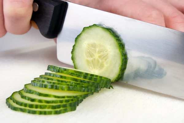 Cutting cucumber to slices with chef knife. — Stock Photo, Image