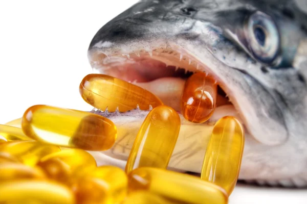 Omega-3 capsules from salmon mouth — Stock Photo, Image