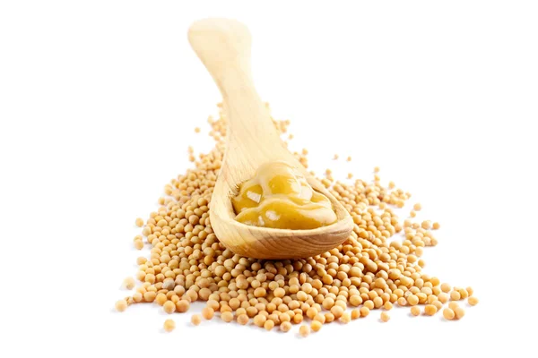 Mustard seeds and wooden spoon — Stock Photo, Image