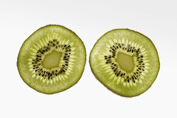 Duas fatias de kiwi no fundo branco gradiente — Fotografia de Stock