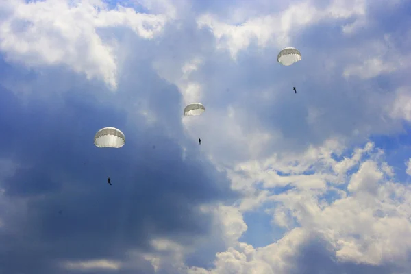 Silhouettes de l'équipe de parachutistes de l'armée contre le ciel dramatique — Photo