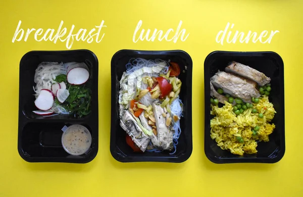 Food in containers for the whole day on a yellow background. Diet for breakfast, lunch and dinner. Proper nutrition and weight loss. With signature dishes