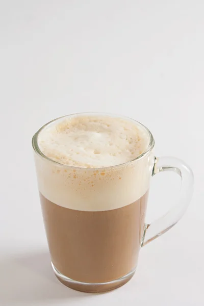 Beyaz masanın üzerine saydam bir fincan kapuçino