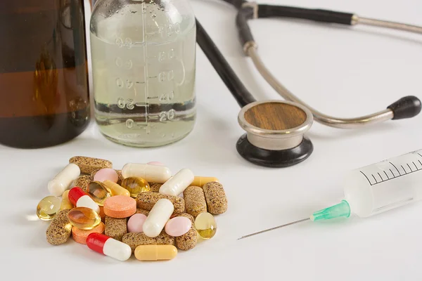 Şırınga, hap, stetoskop beyaz masada