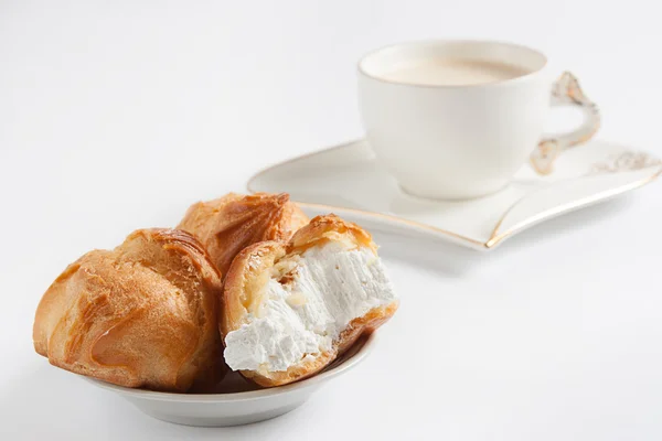 Kahve beyaz Kupası ve eklerleri beyaz zemin üzerine krema ile