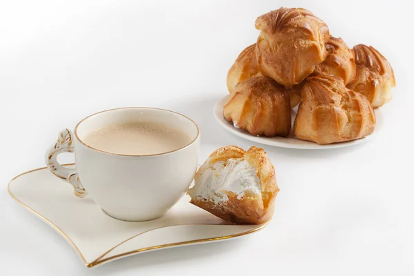 Kahve beyaz Kupası ve eklerleri beyaz zemin üzerine krema ile