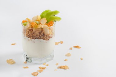 Beyaz bir tabloda bir bardak meyveli yoğurt