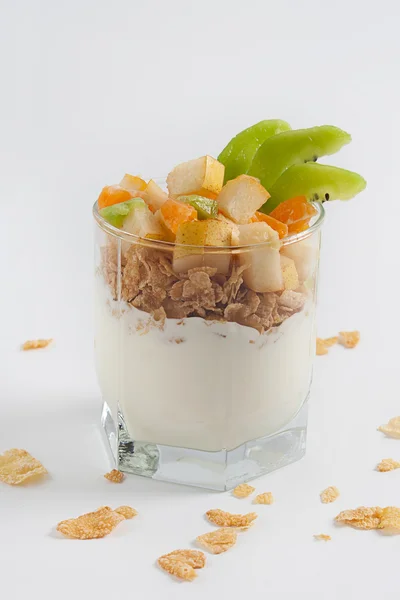 Beyaz bir tabloda bir bardak meyveli yoğurt