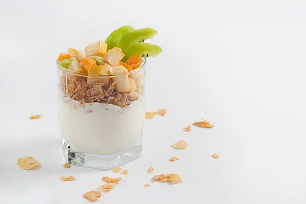 Beyaz bir tabloda bir bardak meyveli yoğurt