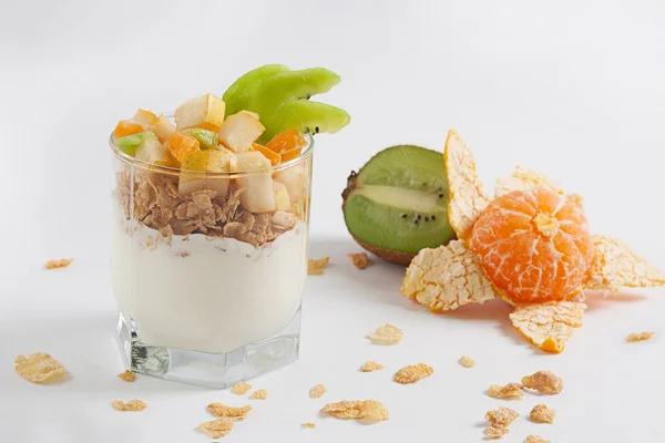 Beyaz bir tabloda bir bardak meyveli yoğurt