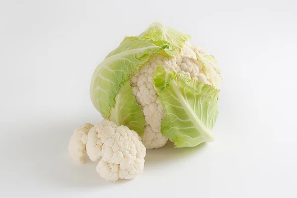 Beyaz arka planda yeşil yapraklı olgun karnabahar