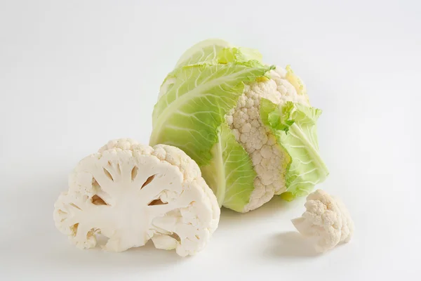 Beyaz arka planda yeşil yapraklı olgun karnabahar