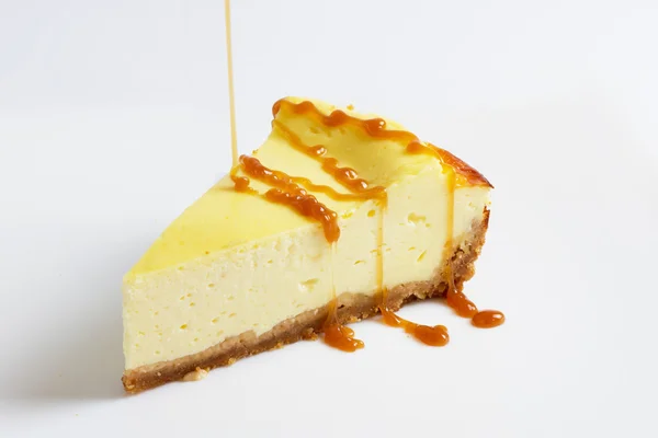 Parçası cheesecake ince bir dere karamel sosu dökün