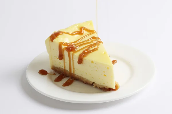 Parçası cheesecake ince bir dere karamel sosu dökün