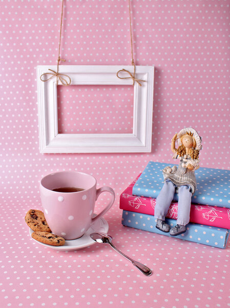 Cup of tea and a book on a pink background