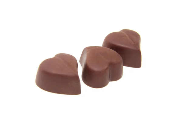 Tři čokoládové bonbóny ve tvaru srdce na bílém pozadí — Stock fotografie