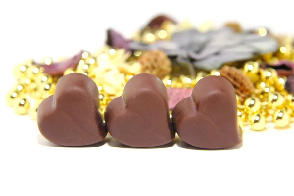 Tres dulces de chocolate en forma de corazón sobre fondo blanco — Foto de Stock